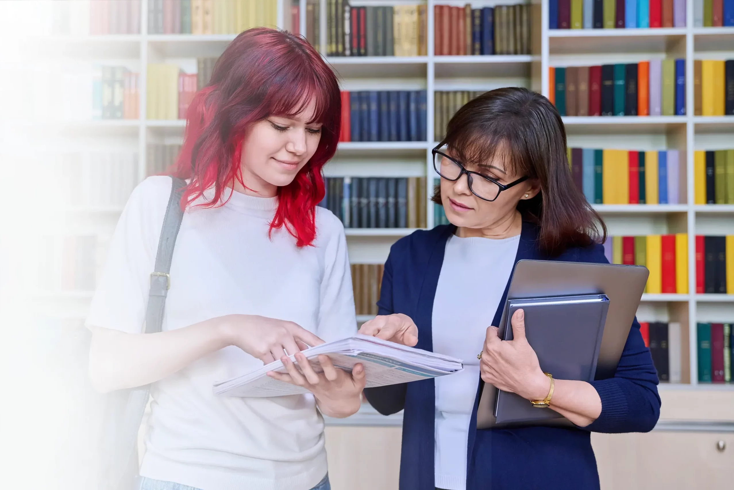 Teenage girl looking at a booklet with the therapist