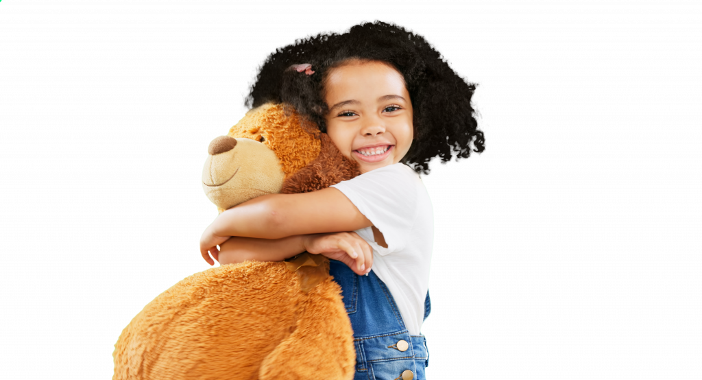 Child holding a teddy bear smiling