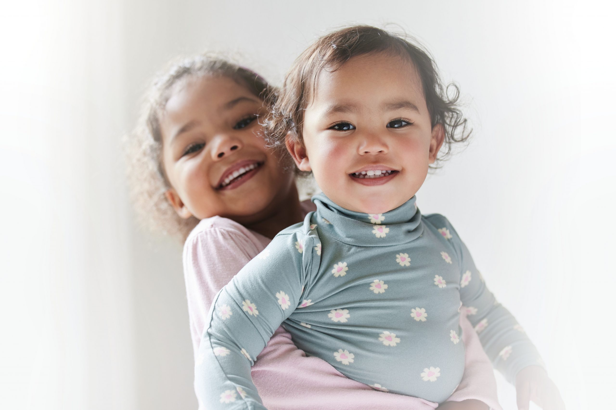 Young girl holding up baby