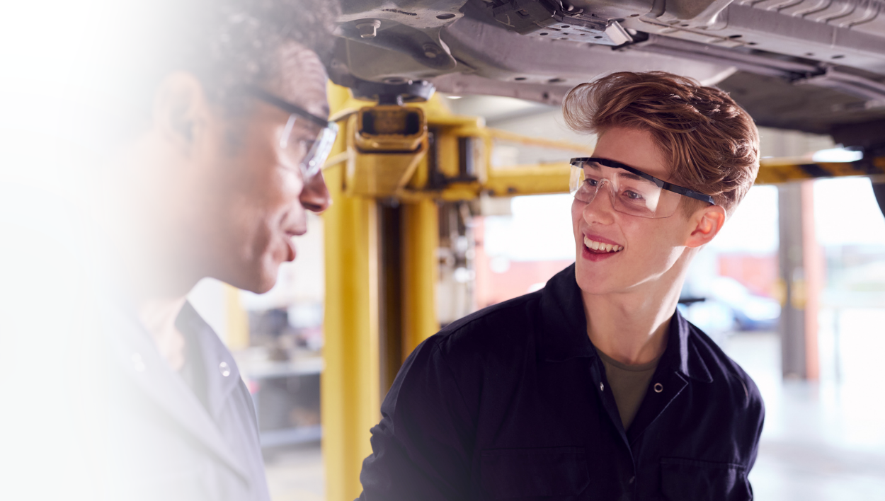 Youth with teacher in auto mechanics class